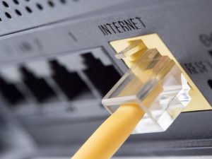 yellow network cable plugged into a router